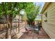 Stone patio features a table and chairs, greenery, and wood fence at 10671 E 28Th Ave, Denver, CO 80238