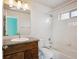Bathroom with a single vanity, white tub, and combined shower with a window providing natural light at 10671 E 28Th Ave, Denver, CO 80238