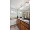 Bathroom featuring a double vanity, built-in tub with shower, and tiled walls at 10671 E 28Th Ave, Denver, CO 80238