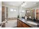 Bathroom featuring a double vanity, built-in tub with shower, and tiled walls at 10671 E 28Th Ave, Denver, CO 80238