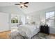 Bright bedroom with a ceiling fan, natural light from two windows, and light walls and flooring at 10671 E 28Th Ave, Denver, CO 80238
