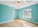Turquoise bedroom with a ceiling fan, natural light from window, and light-colored hardwood flooring at 10671 E 28Th Ave, Denver, CO 80238