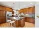 Beautiful kitchen featuring stainless steel appliances, a center island with seating, and modern lighting at 10671 E 28Th Ave, Denver, CO 80238