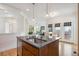 An open-concept kitchen features a kitchen island, stainless steel sink, and access to an adjacent breakfast nook at 10671 E 28Th Ave, Denver, CO 80238
