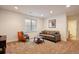 Cozy living room with carpet, a window, sofa with pillows, orange chair, and a coffee table at 10671 E 28Th Ave, Denver, CO 80238