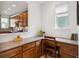 An office nook with wood desk, drawers, and cabinets features an adjacent window for natural light at 10671 E 28Th Ave, Denver, CO 80238