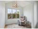 Sun-filled sitting room featuring high ceilings with a chandelier and a comfortable chair with plush accents at 10671 E 28Th Ave, Denver, CO 80238