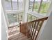 A carpeted staircase with wood banister is illuminated by large windows offering views of the surrounding neighborhood at 10671 E 28Th Ave, Denver, CO 80238