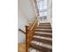 Staircase with carpet steps and wood railing leads to the upper level, bathed in natural light from a large window at 10671 E 28Th Ave, Denver, CO 80238