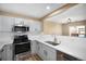 Modern kitchen featuring white cabinets, stainless steel appliances, and quartz countertops at 817 Pintail Ave, Brighton, CO 80601