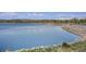 Picturesque lake view with tranquil water, lush greenery, and distant mountain peaks at 817 Pintail Ave, Brighton, CO 80601