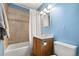 Cozy bathroom with a shower-tub combination, beige tile and natural wood vanity at 1920 Ulster St, Denver, CO 80220