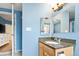 The well-lit bathroom features light blue walls, granite countertops and double mirrors at 1920 Ulster St, Denver, CO 80220