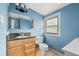 Bright bathroom featuring a granite countertop, natural wood vanity and window at 1920 Ulster St, Denver, CO 80220