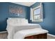 Bedroom with a large window, and a white bed under modern, tree-inspired wall decor at 1920 Ulster St, Denver, CO 80220
