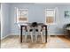 A bright dining area with seating for four under two large windows and neutral walls at 1920 Ulster St, Denver, CO 80220