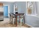 Eat-in dining area with a dark wood table, seating for four, and two bright windows at 1920 Ulster St, Denver, CO 80220