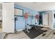 Home gym with weights and fitness equipment on light grey wood look floors at 1920 Ulster St, Denver, CO 80220