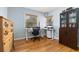Home office with hardwood floors, two windows, a white desk, and a dark brown bookcase at 1920 Ulster St, Denver, CO 80220