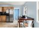 An eat-in dining area next to a kitchen with stainless steel appliances and wood cabinets at 1920 Ulster St, Denver, CO 80220