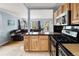 Open-concept kitchen with stainless steel appliances, wood cabinets, and a view into the living room at 1920 Ulster St, Denver, CO 80220