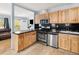 Modern kitchen featuring stainless steel appliances, wood cabinets, and a tiled floor at 1920 Ulster St, Denver, CO 80220