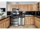 An updated kitchen featuring stainless steel appliances, granite countertops, and wood cabinets at 1920 Ulster St, Denver, CO 80220