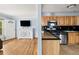 Open-concept living room featuring wood floors, a TV, and an open view to an updated kitchen at 1920 Ulster St, Denver, CO 80220