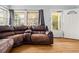 Comfortable living room with hardwood floors and a large leather sectional with a front view window at 1920 Ulster St, Denver, CO 80220