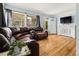 Bright living room featuring hardwood floors, and a leather sectional with a front view window at 1920 Ulster St, Denver, CO 80220