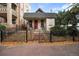 Charming home with red door and black wrought iron fence covered in fall leaves at 1516 Lafayette St, Denver, CO 80218