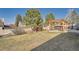 Large backyard with a pergola covered patio area, mature trees, and a privacy fence at 21585 E Powers Cir, Centennial, CO 80015