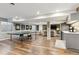 Open basement showcasing wood floors, ping pong table, wet bar and living area with wood accent wall at 1345 Laurel St, Broomfield, CO 80020