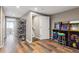 Basement hallway with hardwood floors leading to arcade games and doorway to finished room at 1345 Laurel St, Broomfield, CO 80020