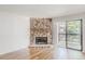 Living room featuring stone fireplace, wood floors, and sliding door to outdoor balcony at 2727 Folsom St # 210, Boulder, CO 80304