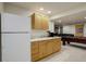 Basement kitchenette featuring light wood cabinets, a sink, and a full sized refrigerator at 15432 Greenstone Cir, Parker, CO 80134
