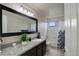 Bathroom featuring a vanity with granite countertop, shower over tub and a large mirror at 15432 Greenstone Cir, Parker, CO 80134