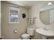 Bathroom with a pedestal sink, round mirror and neutral color scheme at 15432 Greenstone Cir, Parker, CO 80134