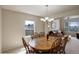 This dining room features hardwood table and seating, traditional chandelier and access to the adjacent living room at 15432 Greenstone Cir, Parker, CO 80134