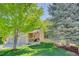 Inviting home with a covered porch, American flag, and mature trees on a well-manicured lawn at 15432 Greenstone Cir, Parker, CO 80134
