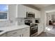 Close-up of kitchen features including quartz countertops, stainless steel appliances, and bright white shaker cabinets at 15432 Greenstone Cir, Parker, CO 80134
