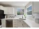 Bright kitchen detail showcasing quartz countertops, stylish backsplash, stainless steel dishwasher and updated sink at 15432 Greenstone Cir, Parker, CO 80134
