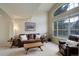 Living room with high ceiling, large windows, and a comfortable seating area with a leather couch and armchair at 15432 Greenstone Cir, Parker, CO 80134