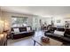 Inviting living room with hardwood floors, ample natural light, and open layout to the dining area, perfect for relaxation at 15432 Greenstone Cir, Parker, CO 80134