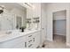 Modern bathroom featuring double sinks, a large mirror with shelving, and a separate shower and closet at 113 Marlowe Dr, Erie, CO 80516