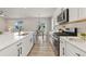 Modern kitchen with white cabinets, stainless steel appliances, and an open floor plan at 113 Marlowe Dr, Erie, CO 80516