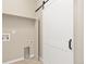Open laundry room with sliding barn door at 113 Marlowe Dr, Erie, CO 80516