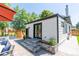 Backyard showcasing a modern shed with black trim, double doors and a stone patio with flower beds at 4467 King St, Denver, CO 80211