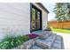 Exterior detail of stone steps and flower beds leading to black framed double doors at 4467 King St, Denver, CO 80211