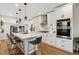 Modern kitchen featuring a large island, stainless steel appliances, and white cabinets at 4467 King St, Denver, CO 80211